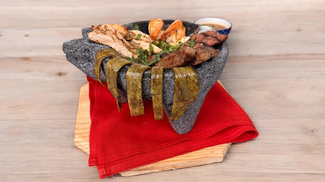 Molcajete stone bowl with grilled meats — cenaduría late supper at Las Piñatas Kitchen Tomball